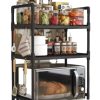 Three-tier Black Kitchen Cart with Spice Jars and Bottles on Top Shelves, a Towel and Utensils Hanging on the Side, and a Toaster Oven on the Bottom Shelf.