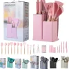 Pink Kitchen Utensil Set with a Matching Pink Organizer and Assorted Tools Displayed with Packaging Boxes in the Background.