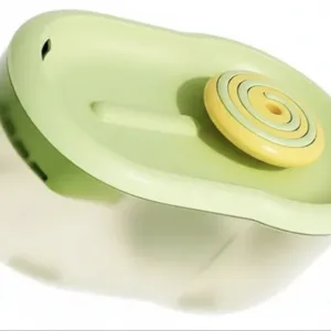 Green Handheld Citrus Juicer with a Yellow Spiral Reamer on Top, Made of Plastic Material.