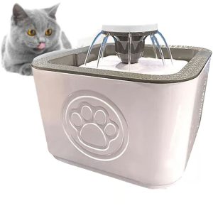 Gray Cat with Yellow Eyes Beside a Pink Pet Water Fountain Featuring a Paw-print Emblem, Tongue Slightly Out.