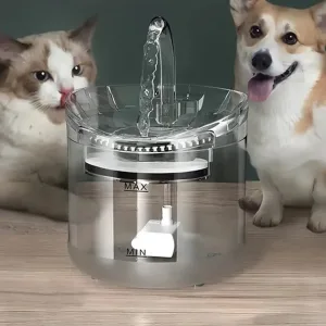 Two Dogs Watch a Clear Pet Water Fountain with Flowing Water and Visible Min/max Level Indicators.